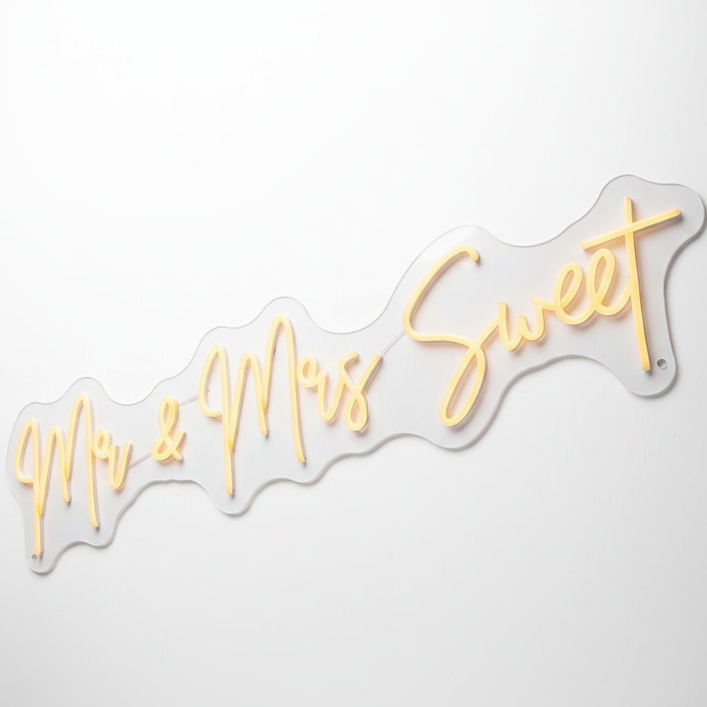 Custom wedding neon sign featuring warm white illuminated script text reading Mr and Mrs Sweet for reception decor.