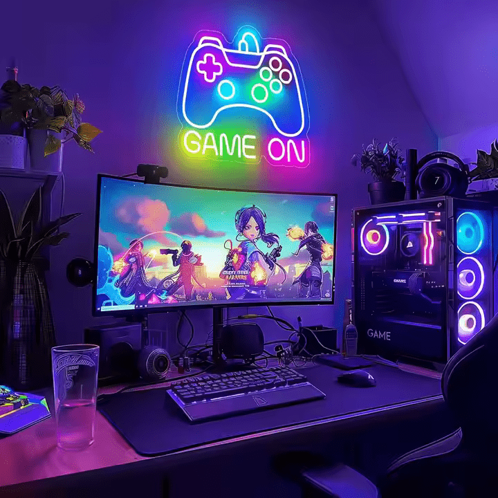 Game On Gamepad neon sign in multicolour LED flex with acrylic backing – mounted above dual-monitor gaming desk and RGB-lit PC