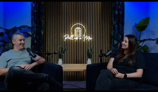 Professional podcast studio featuring custom LED neon sign for "Pull Up A Mic" show with microphone logo, demonstrating branded podcast studio design