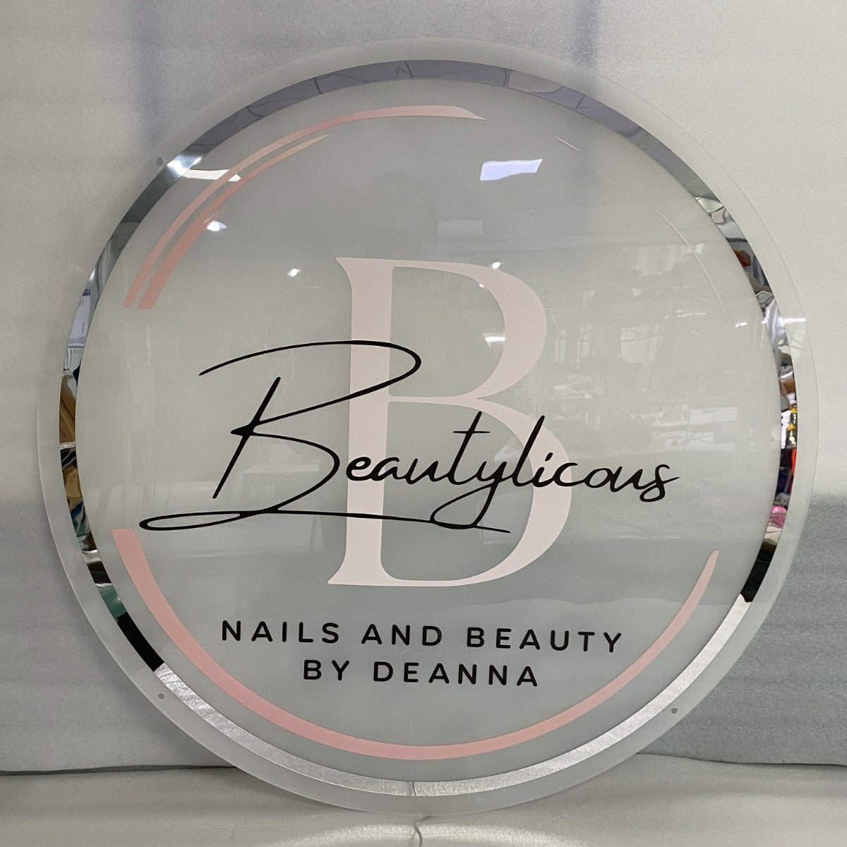 Round backlit acrylic salon sign with printed logo for Beautylicous nails and beauty salon in Basildon, LED wall sign with warm white glow