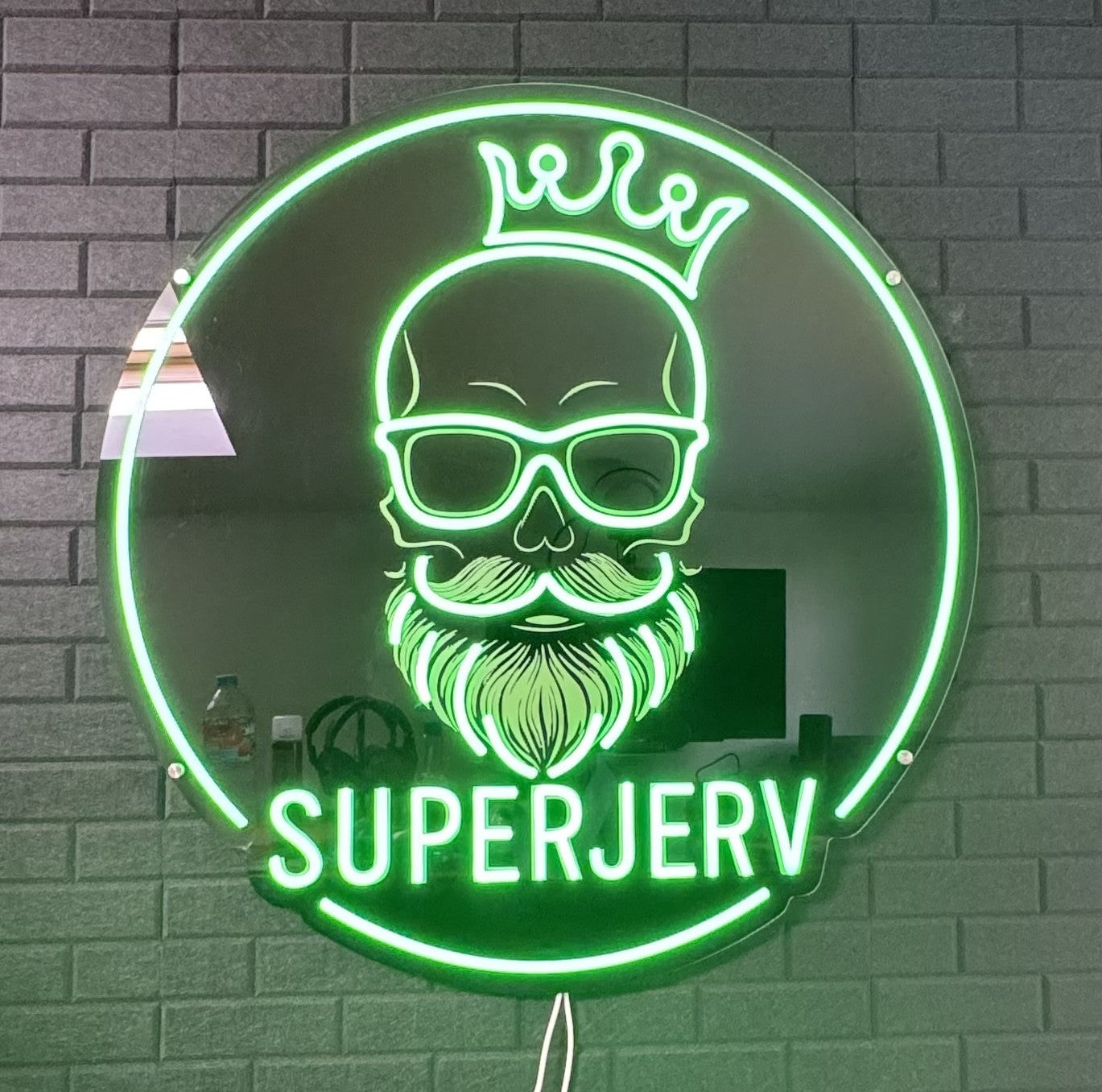 Custom green LED neon sign featuring a bearded skull logo with crown and the text SUPERJERV, mounted on a black acrylic backing for business branding