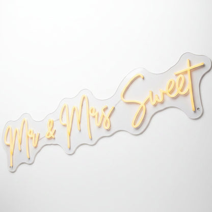 Custom wedding neon sign featuring warm white illuminated script text reading Mr and Mrs Sweet for reception decor.
