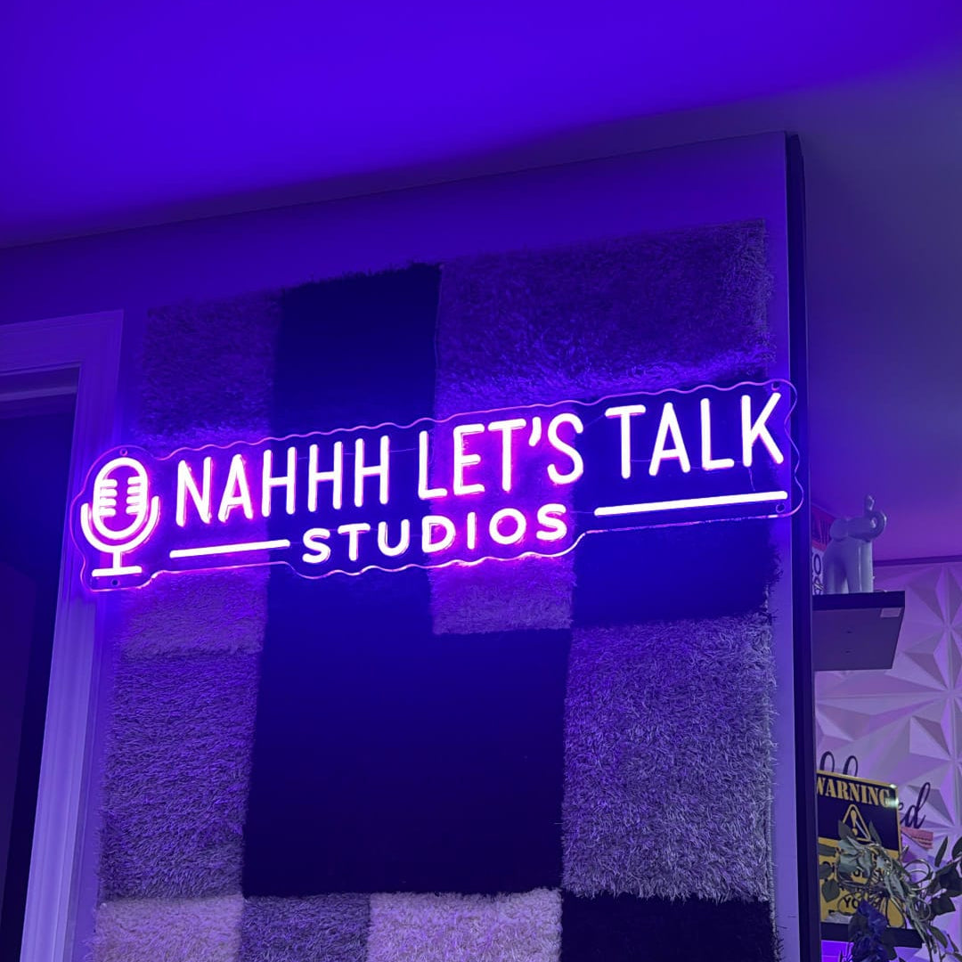 Purple LED neon podcast sign with microphone logo for Nahhh Let's Talk Studios in New York, mounted on textured acoustic panel wall