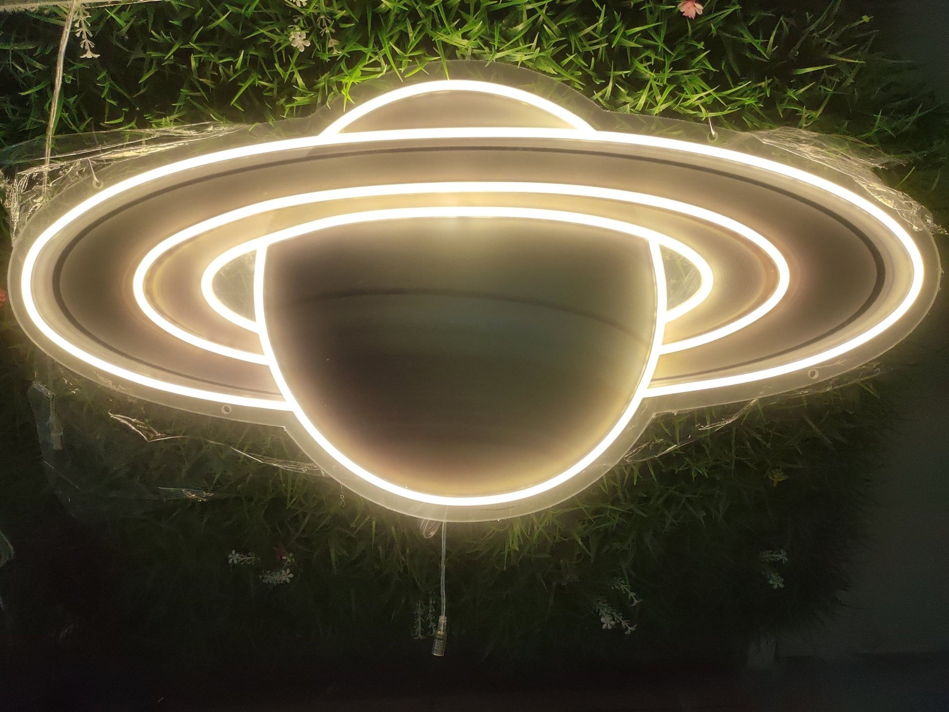 Saturn UV neon sign illuminated with warm white LED showing planet rings on clear acrylic backing
